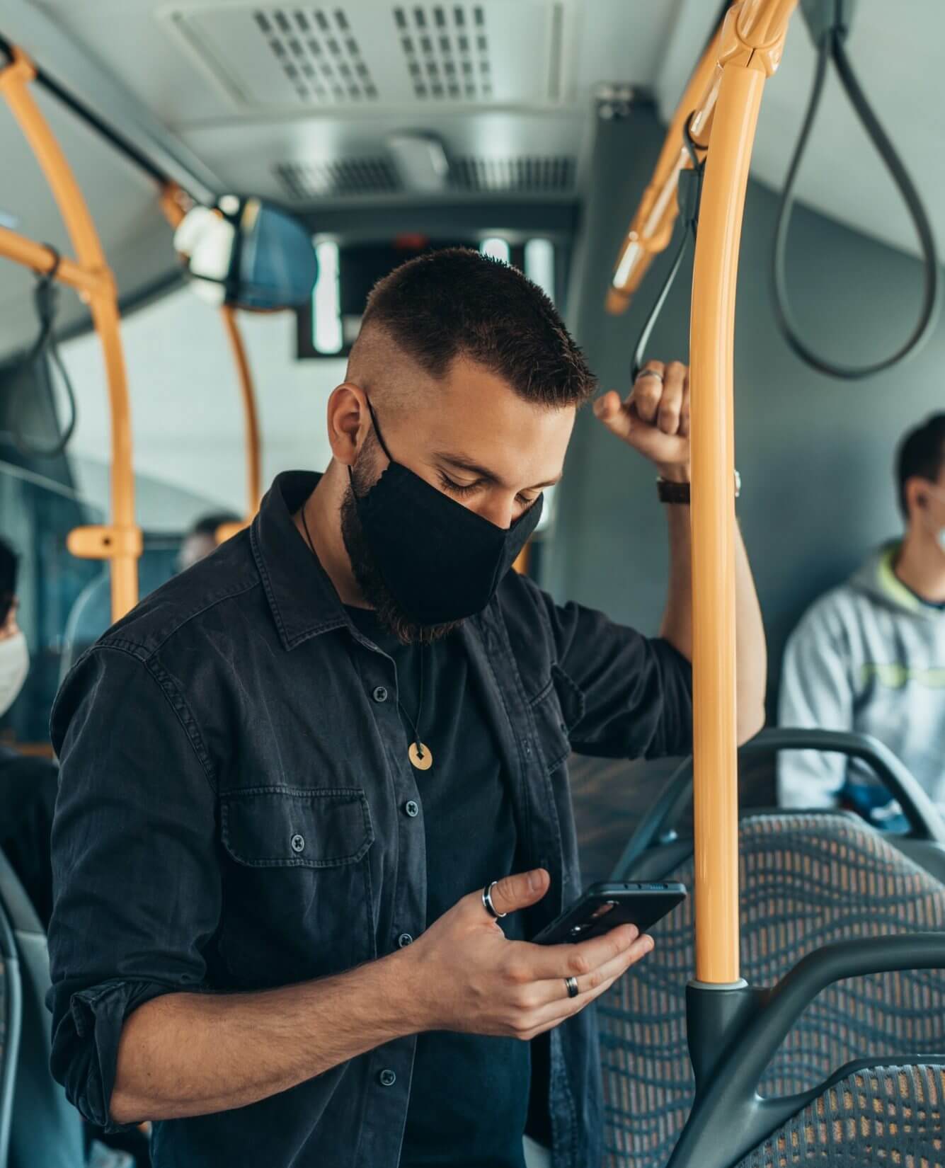 man-wearing-a-protective-mask-and-using-a-smartphone-while-keeping-the-distance-in-the-bus-prjpt30isdxpph0ex0n7m3lqn696yrlwgz1wmbg46s